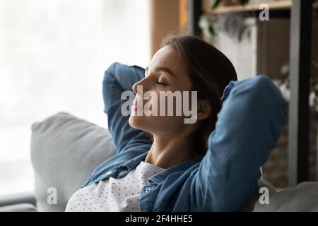 Femme calme en gros plan avec les yeux fermés reposant sur le canapé Banque D'Images