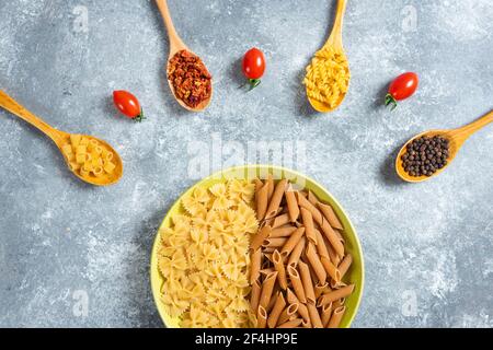Deux sortes de pâtes crues sur l'assiette avec différentes épices Banque D'Images