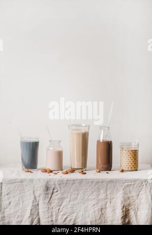 Lait sans lait aux amandes avec matcha, baies, cacao, café en bouteilles Banque D'Images