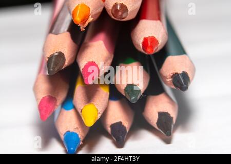 Crayons colorés pour enfants attachés ensemble et pointant vers l'appareil photo. Banque D'Images