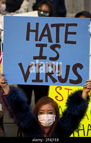 Brooklyn, New York, États-Unis. 21 mars 2021 une femme sur les marches de Brooklyn Borough Hall tient un panneau lisant "la haine est le virus" lors d'un rassemblement contre la violence et la discrimination après des attaques récentes contre les Américains d'origine asiatique à New York et à travers les États-Unis pendant la pandémie COVID-19. Crédit : Joseph Reid/Alay Live News Banque D'Images