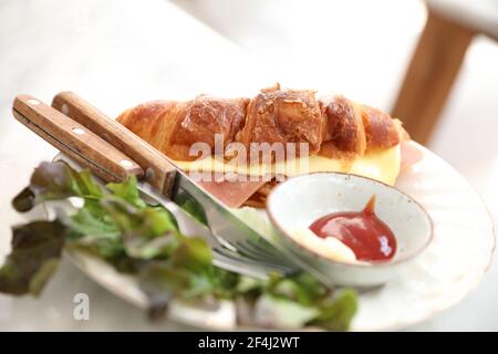 Sandwich au jambon et au fromage sur une table blanche dans le café Banque D'Images