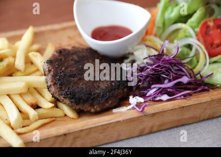 Côtelettes de bœuf pour steak avec feux et légumes sur bois arrière-plan Banque D'Images