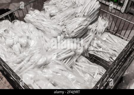 Un ensemble de vaisselle en plastique blanc jetable dans un emballage cellophane dans un magasin. Banque D'Images