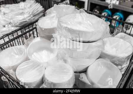 Un ensemble de vaisselle en plastique blanc jetable dans un emballage cellophane dans un magasin. Banque D'Images