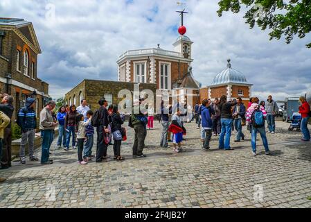 19 2010 juin - Greenwich, Angleterre. Les visiteurs se sont enjamber à cheval sur le méridien principal, avec un pied dans l'hémisphère occidental et l'autre dans l'hémisphère oriental Banque D'Images