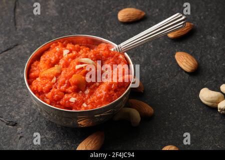 Gajar ka halwa est un dessert sucré à base de carottes provenant de l'Inde. Garni de noix de cajou et d'amandes et servi dans un bol. Banque D'Images