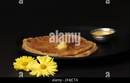 Puran Poli, également connu sous le nom d'Holige, est un pain plat sucré indien consommé principalement pendant le festival Holi. Servi dans une assiette avec du ghee pur. Banque D'Images