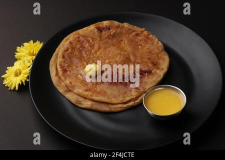 Puran Poli, également connu sous le nom d'Holige, est un pain plat sucré indien consommé principalement pendant le festival Holi. Servi dans une assiette avec du ghee pur. Banque D'Images