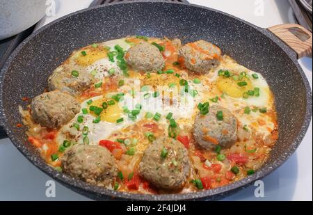 Régime de céto. Petit-déjeuner maison composé de boulettes de viande frites, de tomates, d'oignons de printemps et d'œufs dans la poêle. Keto, paleo nourriture. Banque D'Images