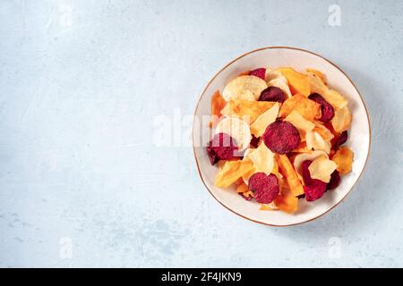 Chips de fruits et de légumes sur une assiette, grenaille au-dessus Banque D'Images