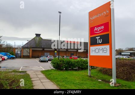 Flint; Royaume-Uni: 28 janvier 2021: La signalisation à côté d'un supermarché Sainsbury montre certaines des marques en magasin, y compris Argos qui a récemment déménagé à l'intérieur de t Banque D'Images