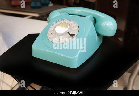 Téléphone à cadran rotatif turquoise des années 70 sur la table de séjour Banque D'Images