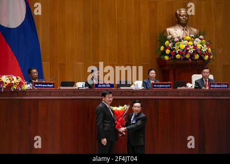 (210322) -- VIENTIANE, 22 mars 2021 (Xinhua) -- Le Premier ministre lao nouvellement élu, Phankham Viphavanh (R, front), présente des fleurs à Thongloun Sisoulith, qui vient d'être élu nouveau président du pays, lors de la session inaugurale de la neuvième législature de l'Assemblée nationale lao à Vientiane, au Laos, le 22 mars 2021. La session inaugurale en cours de la neuvième législature de l'Assemblée nationale lao (NA) a élu lundi matin Thongloun Sisoulith, secrétaire général du Comité central du Parti révolutionnaire populaire lao (PRPS), en remplacement de Bounnhang Vo, le nouveau président du pays Banque D'Images