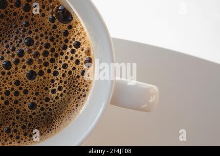 Gros plan d'une tasse blanche avec du café noir chaud Banque D'Images