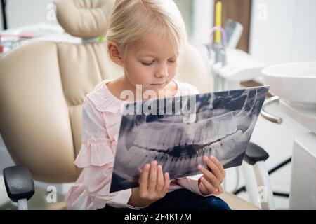 Gros plan d'une petite fille mignonne examinant un rayons x d'un j Banque D'Images