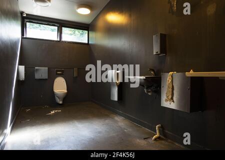 Papier toilette sur le sol dans une salle de bains sale Banque D'Images