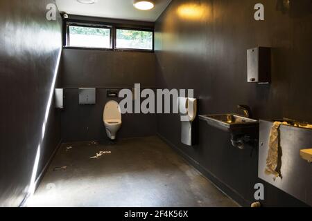 Papier toilette sur le sol dans une salle de bains sale Banque D'Images