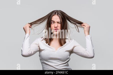 Femme frustrée ayant de mauvais cheveux. Femme ayant un mauvais cheveux, ses cheveux sont désordonnés et emmêlés. Cheveux salissants. Brunette femme aux poils disgracieux. Fille ayant Banque D'Images