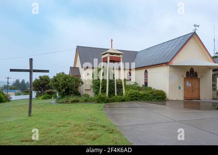 Avec sa cloche de cour d'église séparée et son toit en bois et en acier, l'église anglicane All Saints classée en 1911 à Bermagui est un modeste bâtiment Banque D'Images