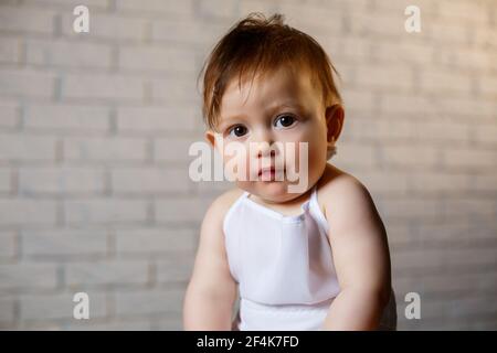 Petit garçon dans un chapeau et avec du pain. Petit enfant habillé comme un cuisinier dans la cuisine. Banque D'Images