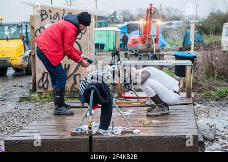 Calais, France. De migrants érythréens dans la jungle de Calais, lave son entendre à une méthode locale waterpoint. Banque D'Images