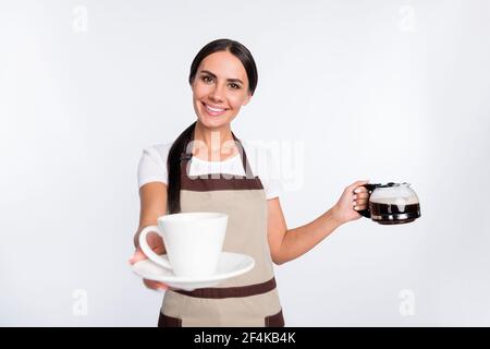 Photo d'optimiste beau brun cheveux dame donner l'usure de la tasse tablier de t-shirt isolé sur fond gris Banque D'Images