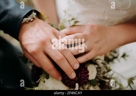 anneaux de mariage sur les mains avec homme montres Banque D'Images