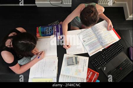 Photo du dossier en date du 20/04/20 de Lulu Byrne, 13 ans, et de Maisy Byrne, 15 ans, qui participent à l'enseignement à domicile, étudie la mathmatique, l'anglais et les sciences depuis leur domicile de Liverpool. Mardi marque le premier anniversaire de l'annonce, le 23 mars 2020, du premier confinement à l'échelle du Royaume-Uni. Date de publication : lundi 22 mars 2021. Banque D'Images