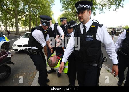 Photo du dossier datée du 02/05/20, d'un homme transporté par des policiers au cours d'une manifestation contre le confinement de Covid-19 à l'extérieur du New Scotland Yard à Londres. Mardi marque le premier anniversaire de l'annonce, le 23 mars 2020, du premier confinement à l'échelle du Royaume-Uni. Date de publication : lundi 22 mars 2021. Banque D'Images