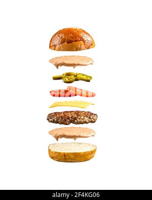 Ingrédients de hamburger flottants isolés sur le blanc Banque D'Images