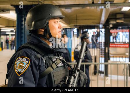 New York, États-Unis. Homme de police ferme avec des équipements et des armes à feu protégeant la station de métro juste après les attaques terroristes de Bruxelles. Banque D'Images