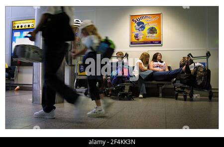 PASSAGERS RETARDÉS À L'AÉROPORT DE GATWICK JUILLET 2001 L'ÉTÉ COMMENCE ICI une publicité sur le mur de Gatwick. Les passagers attendent, se précipitent, se reposent sur la file d'attente, etc. Tous les éléments de l'existence quotidienne des gatewicks, à l'avance sont les vacances d'été et encore plus de retards et d'annulations prévus pour le public voyageur. Banque D'Images