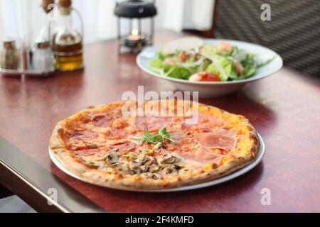 Plats du restaurant avec des ingrédients frais - pizza et salade fraîche Banque D'Images