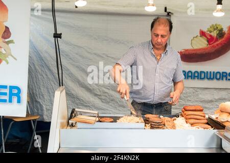 Rotterdam, pays-Bas. Adulte moyen marché caucasien propriétaire de stalle de saucisses et de hamburgers au marché Afrikaanderplein samedi. Banque D'Images