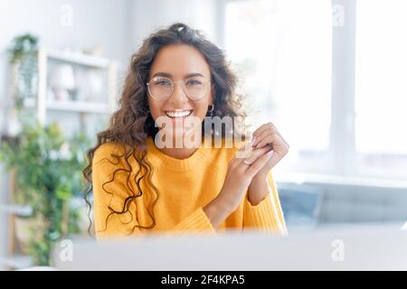 Une jeune femme utilise un ordinateur portable. Drôle de fille ayant le plaisir de rester à la maison. Banque D'Images