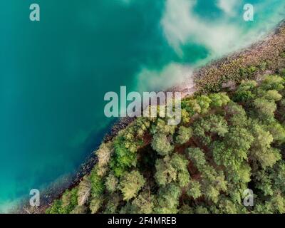 Vue d'en haut de l'antenne de belles eaux du lac Gela. Birds Eye View of scenic Emerald Lake entouré de forêts de pins. Les nuages se reflétant dans Ge Banque D'Images