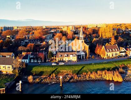 Il s'agit d'une image de drone, prise le long de la rivière néerlandaise Merwede, qui montre la partie du village de Papendrecht. L'église principale est visible. Banque D'Images