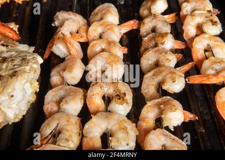 Crevettes sur brochettes cuisant sur un grill Banque D'Images