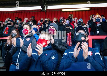 Les fans et les spectateurs regardent le match de football de la ligue inférieure pendant Covid-19, pandémie du coronavirus en Angleterre, au Royaume-Uni. Porter des revêtements de visage et des masques de visage. Banque D'Images