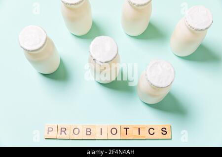 Petits flacons avec probiotiques et prébiotiques boisson laitière sur fond bleu. Production avec des additifs biologiquement actifs. Fermentation et régime guérir Banque D'Images