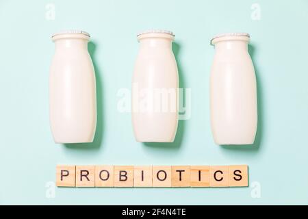 Petits flacons avec probiotiques et prébiotiques boisson laitière sur fond bleu. Production avec des additifs biologiquement actifs. Fermentation et régime guérir Banque D'Images