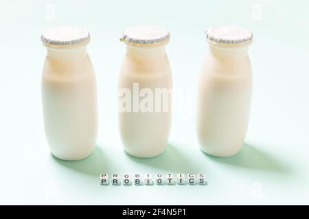 Petits flacons avec probiotiques et prébiotiques boisson laitière sur fond bleu. Production avec des additifs biologiquement actifs. Fermentation et régime guérir Banque D'Images