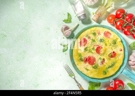 Cuisine méditerranéenne, recette de Keto, omelette saine de frittata avec légumes et fromage, sur fond vert clair copie espace vue de dessus Banque D'Images