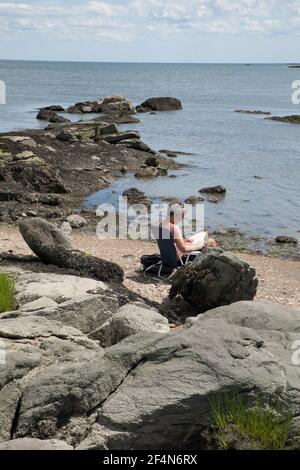 L'homme aime lire au soleil le long du parc de l'île de Chaffince. Banque D'Images