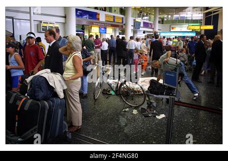 PASSAGERS RETARDÉS À L'AÉROPORT DE GATWICK JUILLET 2001 UN voyageur décompresse et assemble son vélo au milieu de la concorse causant une obstruction tandis que d'autres passagers attendent, se précipitent, se reposent file d'attente, etc tout ce qui fait partie de l'existence quotidienne de gatewicks, Les vacances d'été sont à venir et encore plus de retards et d'annulations prévus pour le public voyageur. Banque D'Images