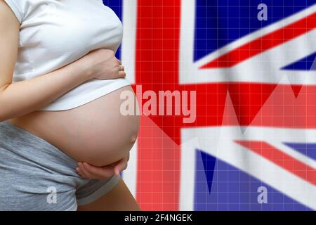 Concept de fécondité au Royaume-Uni de Grande-Bretagne et d'Irlande du Nord. Femme enceinte sur le fond du drapeau avec des graphiques Banque D'Images