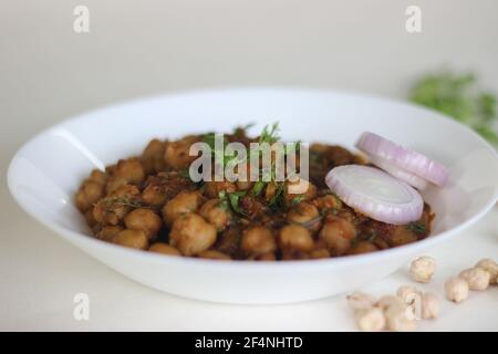 Sauce épicée aux pois chiches blancs faite en trempant les pois chiches pendant la nuit et cuits dans une sauce d'oignons, de tomates, de gingembre, d'ail et d'épices. Prise de vue sur fond blanc Banque D'Images