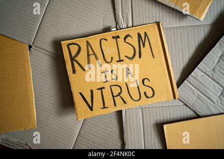 Le racisme est un virus a été écrit sur un carton Banque D'Images