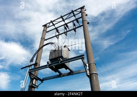 Transformateur électrique rural contre ciel nuageux Banque D'Images